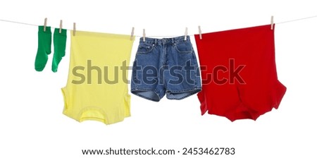 Different clothes drying on laundry line against white background