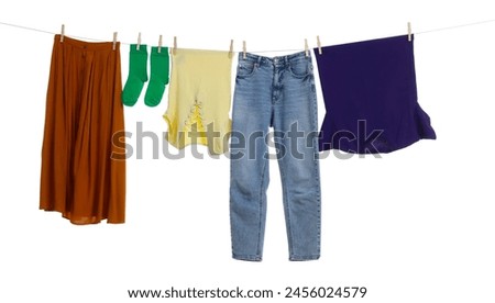 Different clothes drying on laundry line against white background