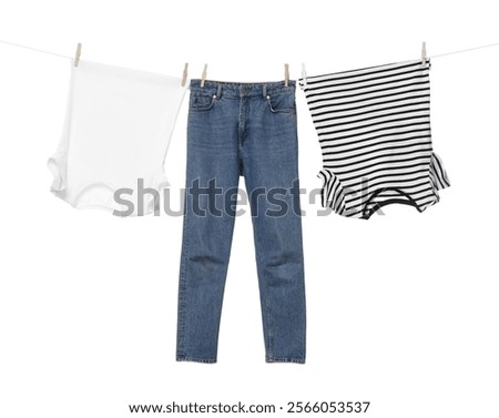 Different clothes drying on laundry line against white background