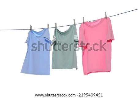 Different clothes drying on washing line against white background
