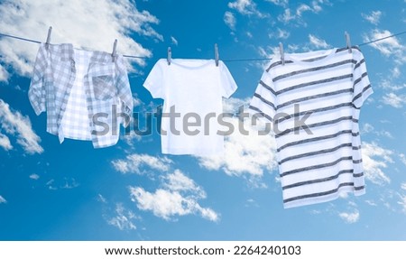 Different clothes drying on washing line against sky