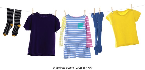 Different clothes drying while hanging on clothesline against white background