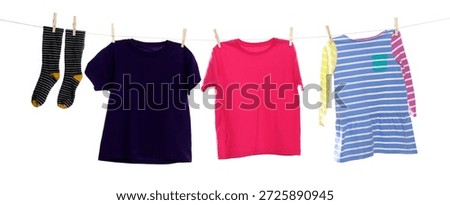 Different clothes drying while hanging on clothesline against white background