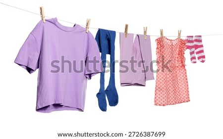 Different clothes drying while hanging on clothesline against white background