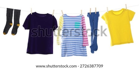 Different clothes drying while hanging on clothesline against white background