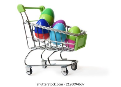 Different color eggs in mini shopping trolley. Concept delivery home purchase for easter eggs hunt. Selective focus
