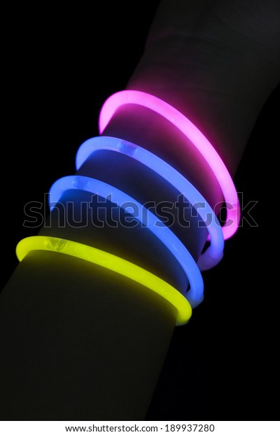 Different color glow\
stick bracelets on\
hand