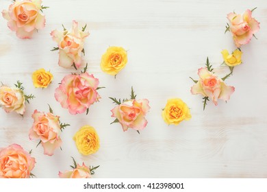 Different color rose flowers  on rustic  background. Top view, vintage toned image, blank space
