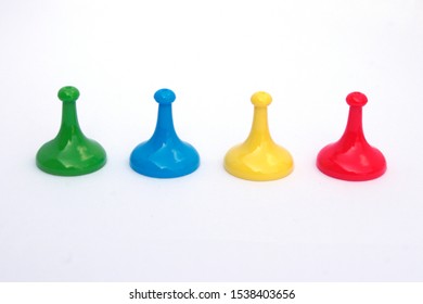 different colored board game movers on white background
