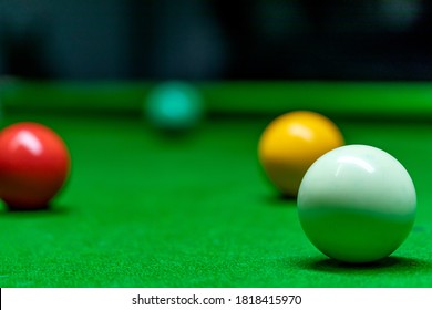 Different colored snooker balls scattered on the snooker table. 