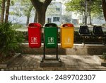  Different colored trash cans in the park. separate trash, sort waste to be recycled again. examples of modern trash cans                              