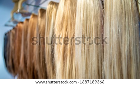 different colored and different types of wigs displayed in the shop