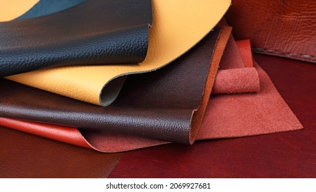 Different colors natural leather textures samples on brown leather background