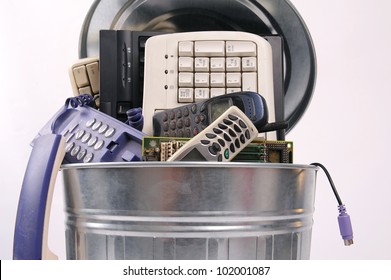 Different Computer Parts And Phone In Trash Can