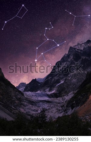Different constellations in starry sky over mountains at night