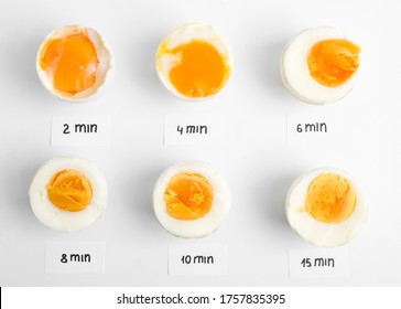 Different cooking time and readiness stages of boiled chicken eggs on white background, flat lay