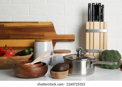 Different cooking utensils and fresh vegetables on countertop in kitchen - Powered by Shutterstock