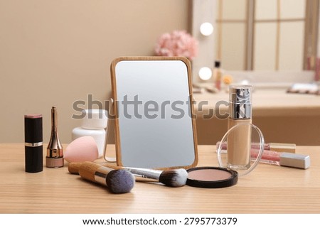 Different cosmetics, makeup brushes and mirror on table in living room, closeup
