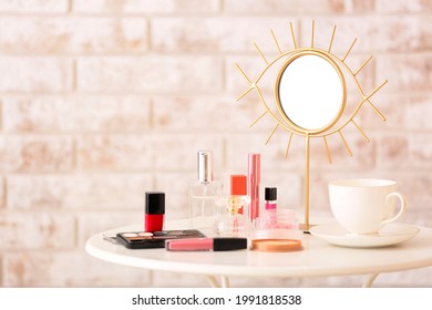 Different cosmetics and mirror on table in room
