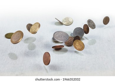 Different countries coins falling down on the white canvass surface. Coins levitating in the air  