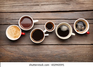 Different Cups Of Coffee On Wooden Table, Top View