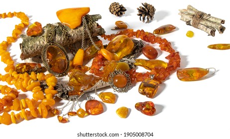 Different Dazzling Old Baltic Amber Jewelry Is Beautifully Laid Out On A Birch Bark On A White Surface. Amber Texture, Amber Pendant, Earrings, Necklace, Brooch And Amber Stones.