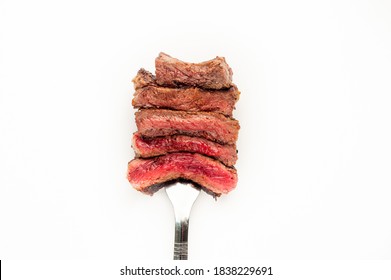 Different Degrees Of Roasting Steak On A Meat Fork On A White Background