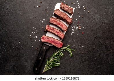 Different Degrees Of Roasting Steak On A Meat Knife On A Stone Background