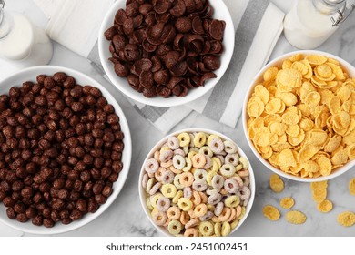 Different delicious breakfast cereals and milk on white marble table, flat lay - Powered by Shutterstock