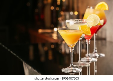 Different delicious cocktails on black table in bar. Space for text - Shutterstock ID 1901407303