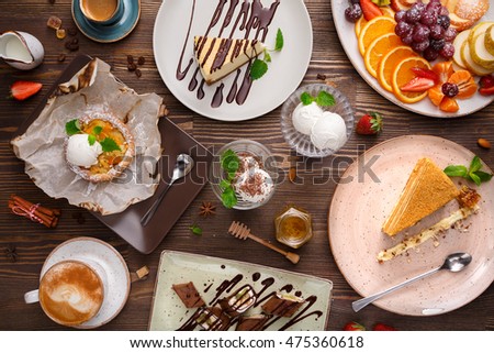 Different desserts with fruits and coffee, top view