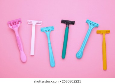 Different disposable razors on a pink background