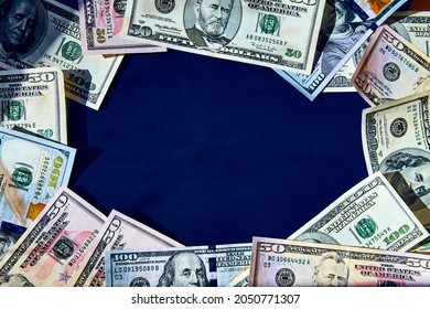 different dollar bills lie in the form of a frame on a dark blue background