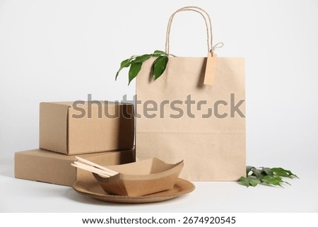 Different eco friendly packaging and leaves on white background