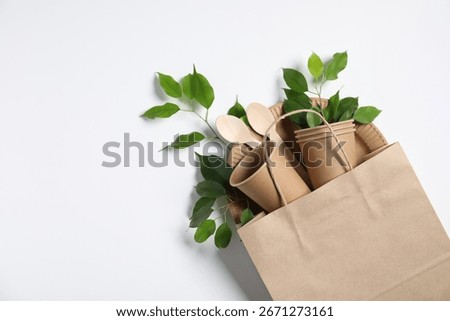 Different eco friendly packaging, tableware and leaves on white background, flat lay. Space for text