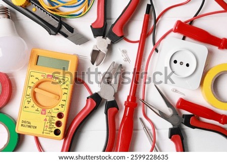 Different electrical tools on white wooden table, flat lay