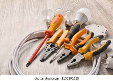 Different electrician's supplies on wooden floor
