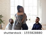 Different ethnicity people gathered together in rehab center try overcome addiction or mental problems, african woman psychologist counsellor hugging girl supporting her, group therapy session concept