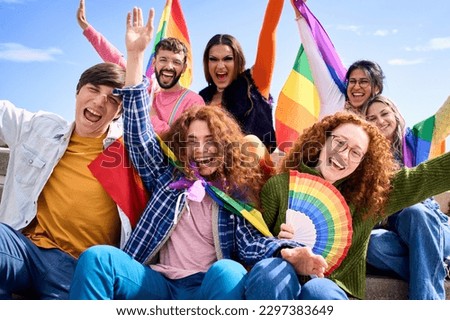 Different excited young friends group celebrating gay pride festival day together. Joyful people LGBT community pose funny looking at camera outdoors. Lesbian, gay, transgender and non-binary.