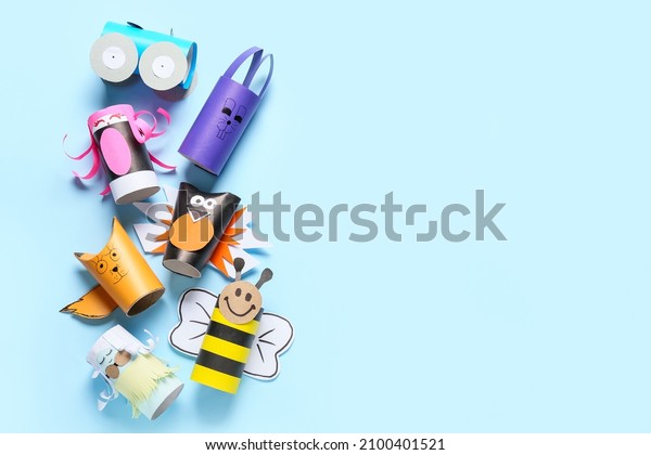 Different figures made of cardboard tubes for\
toilet paper on blue\
background