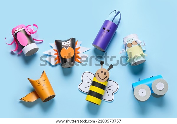 Different figures made of cardboard tubes for\
toilet paper on blue\
background