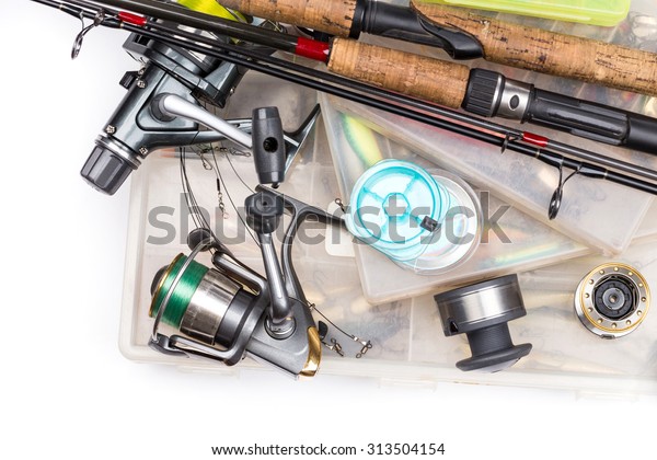 different fishing tackles - rod, reel, line\
and lures in box on white\
background