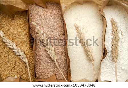 Different flour of wheat cereal in bakery bags.Texture of four wheat in mill:milled wheat sprouts, wheat bran,semolina flour,durum.Top view 