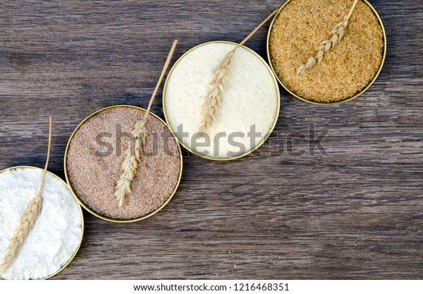 Different\
flour of wheat cereal in circle pots.Texture of four wheat in\
mill:milled wheat sprouts, wheat bran,semolina flour,durum.Storage\
in kitchen closet,Flat lay,copy space for\
text