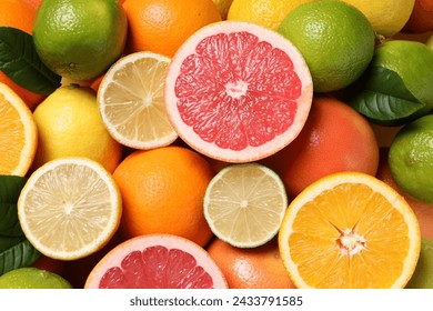 Different fresh citrus fruits and leaves as background, top view - Powered by Shutterstock