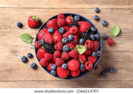 Different fresh ripe berries on wooden table, flat lay