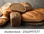 Different freshly baked bread loafs on grey table, closeup