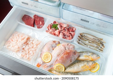 different frozen meat on the opening freezer shelves. food storage.