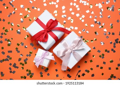 Different Gift Boxes And Confetti On Orange Background, Flat Lay