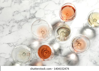 Different Glasses With Wine On Marble Background, Flat Lay